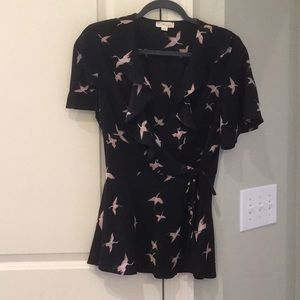 Black bird print wrap top with ruffle neckline.